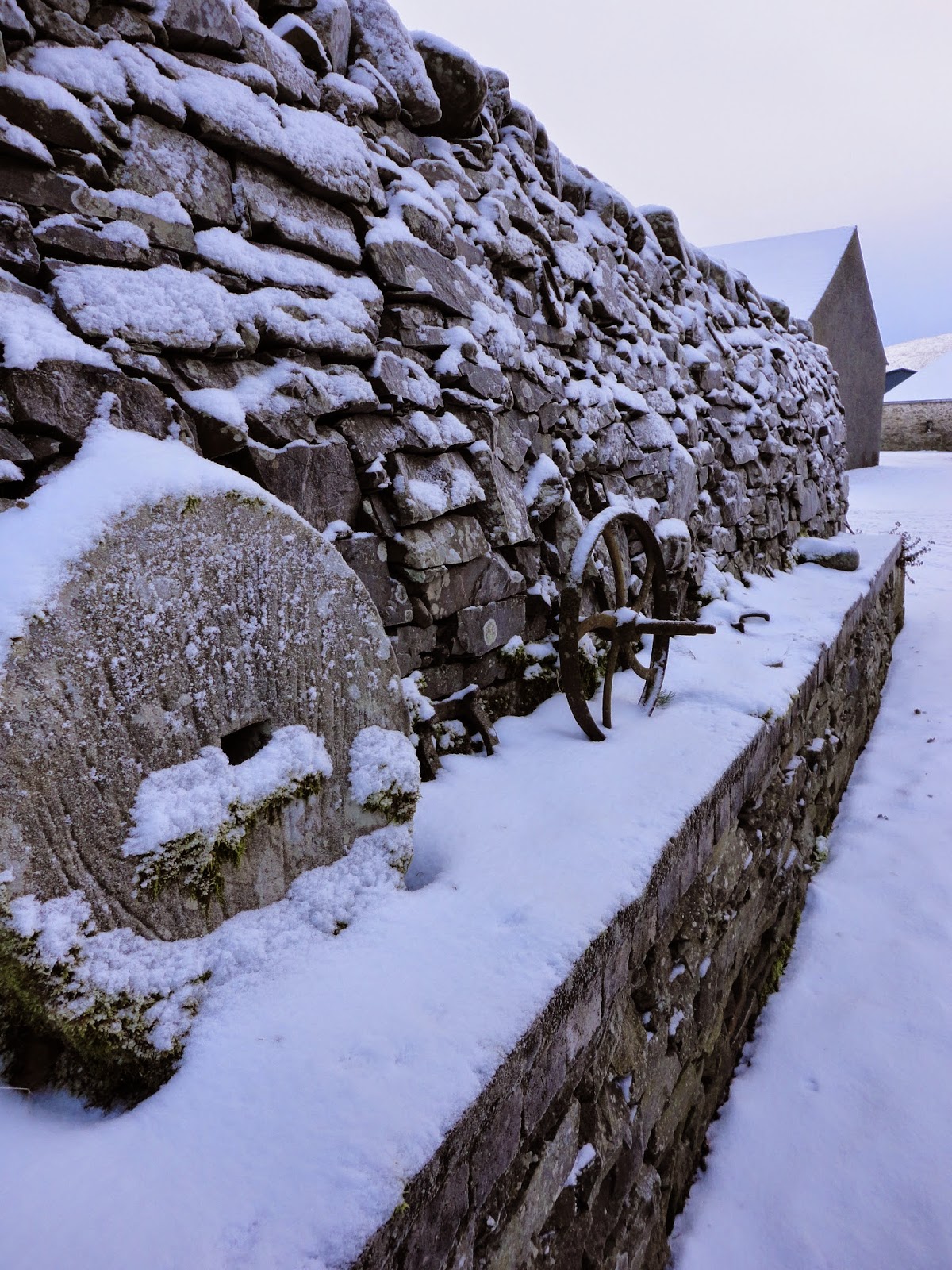 country farm wall with curling stones and snow in winter in scotland