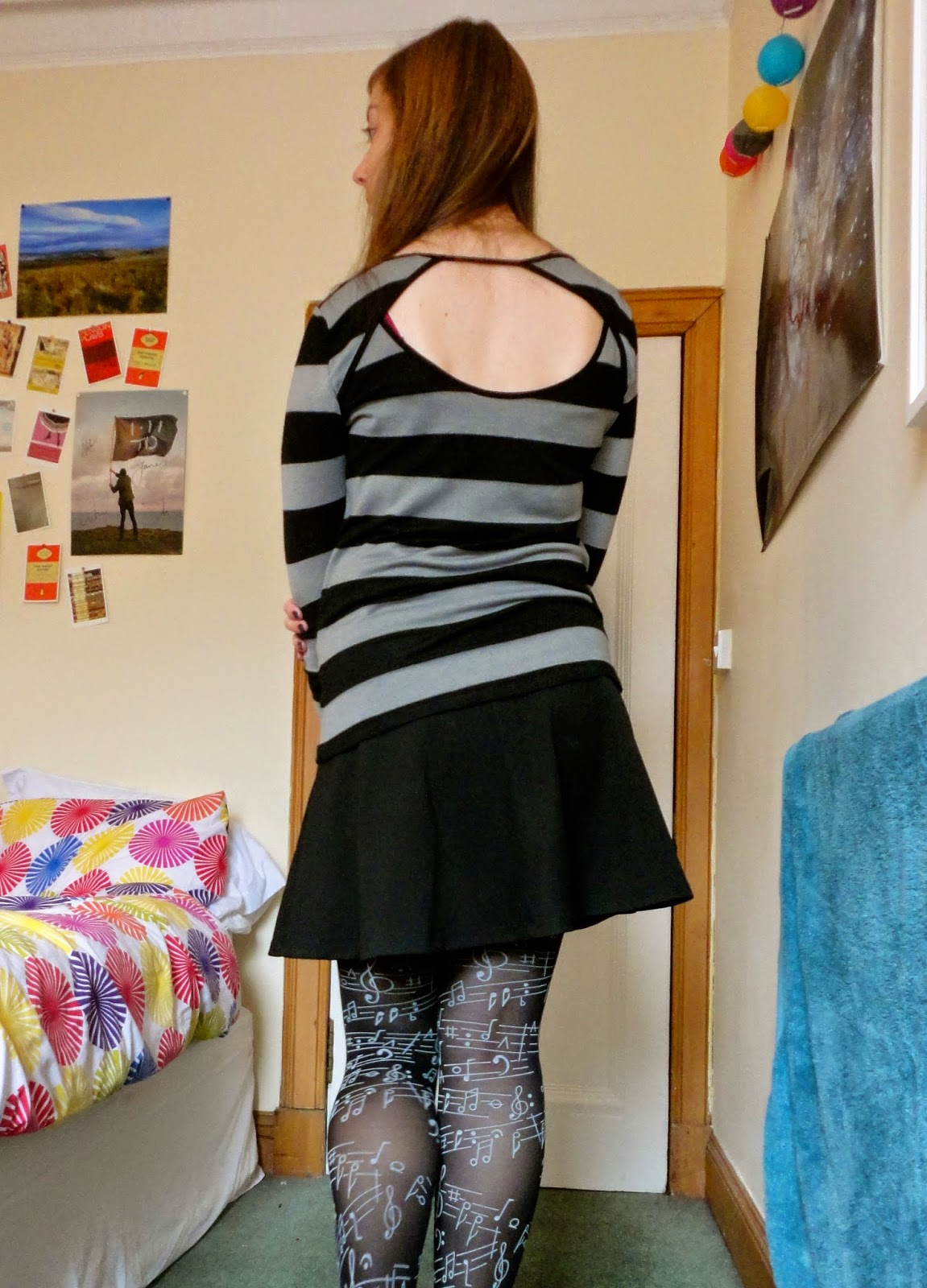 outfit of striped jumper with cut out back, black skirt and musical tights