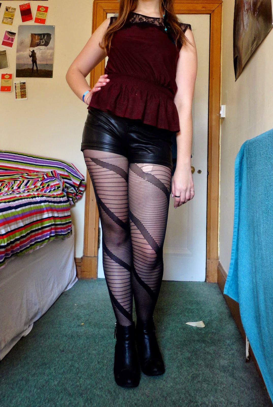outfit of red peplum top with black lace, black fake leather shorts, striped tights and heeled ankle boots