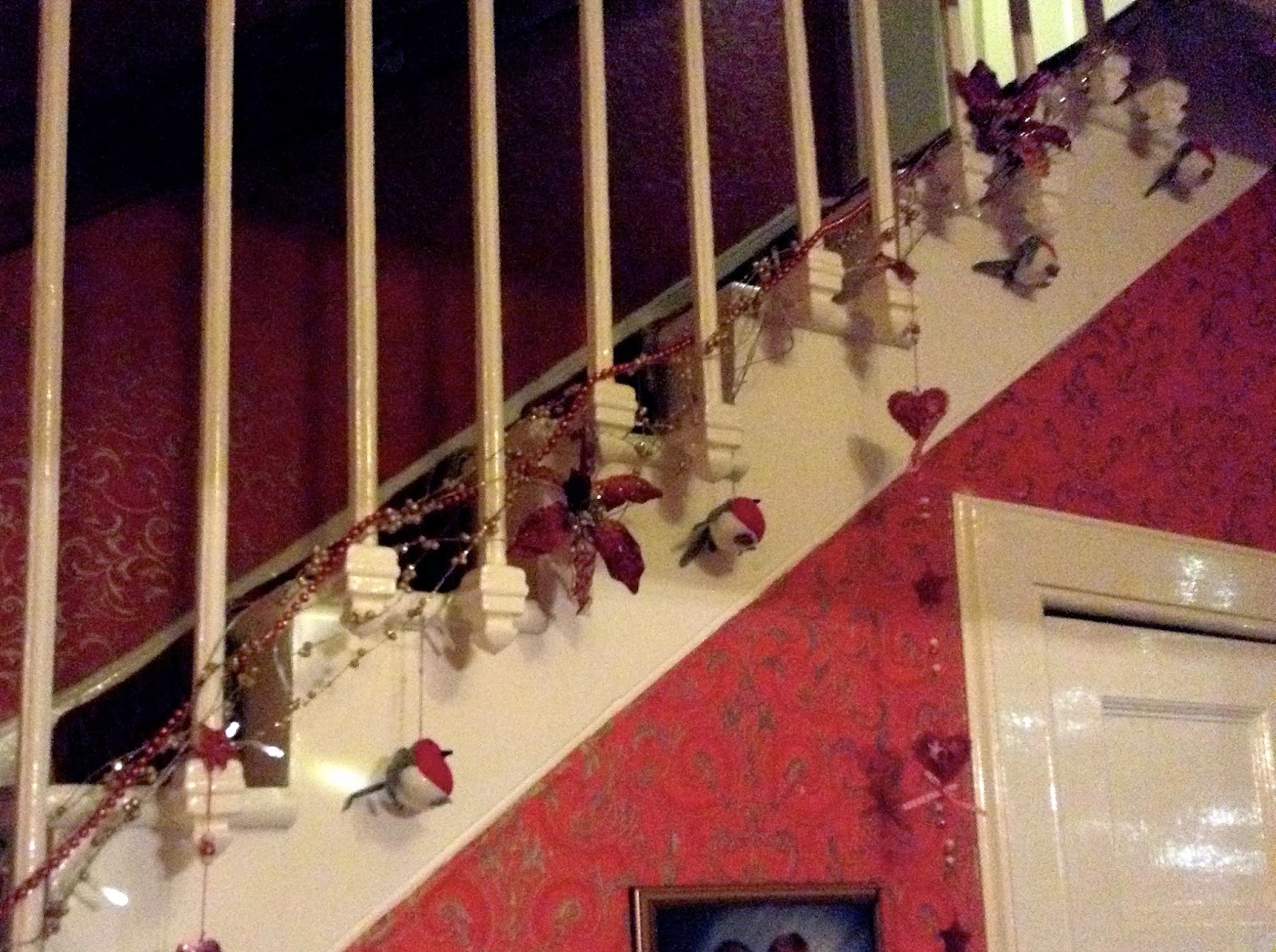 Christmas decorations on stairs - robins, flowers, red & gold beading and dangling hearts