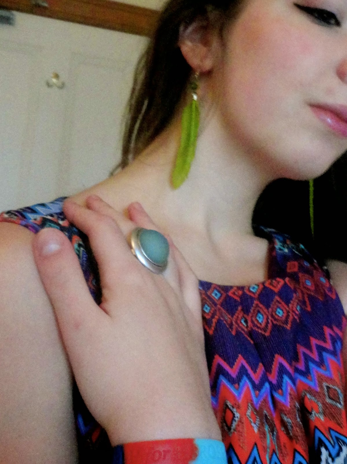 Tropical | outfit jewellery details of green feather earrings and large blue stone ring