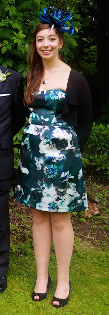Turquoise Tranquility - wedding outfit of blue and green floral strapless dress with matching fascinator and black jacket and shoes