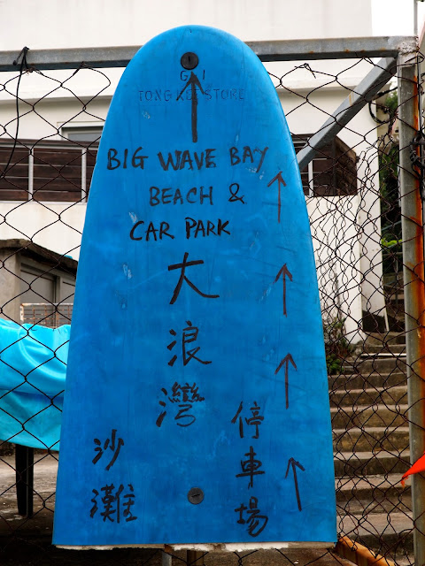 Blue surfboard sign for Big Wave Bay Beach, Hong Kong Island