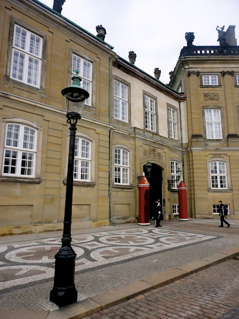 Close up of Amalienborg Palace, with guard and lamp post, in Copenhagen, Denmark