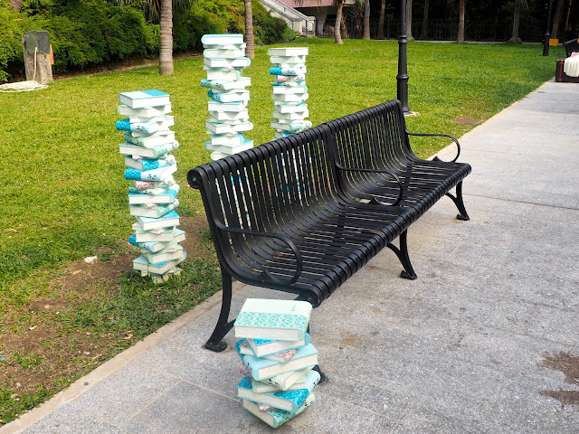 Art display of stacks of books around a park bench near Repulse Bay Beach, Hong Kong