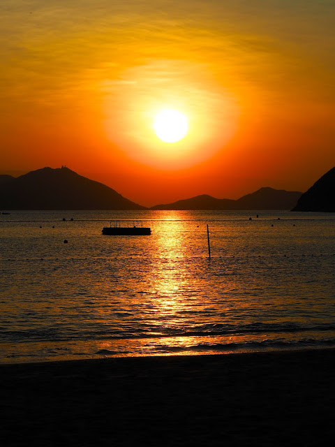 Gold, red and orange of the sunset over the ocean at Repulse Bay Beach, Hong Kong