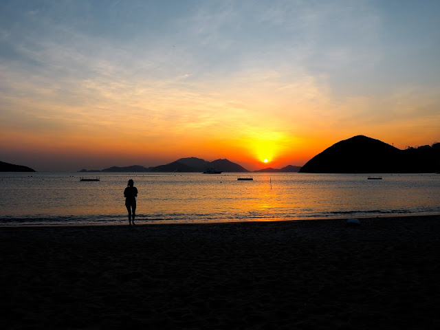 Silhouette of a girl on the beach, with the sunset over the ocean on Repulse Bay Beach, Hong Kong