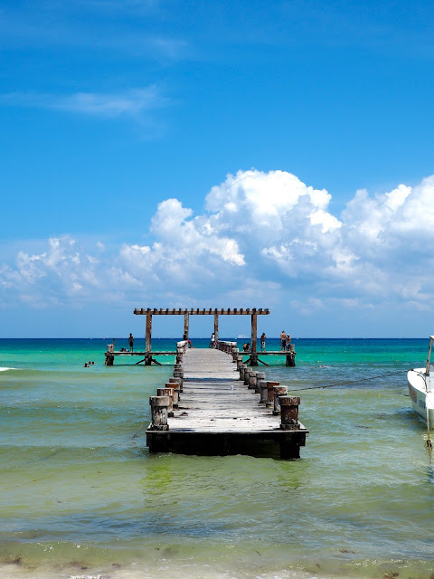 Wooden pier in the turquoise blue ocean at Playa del Carmen beach, Mexico