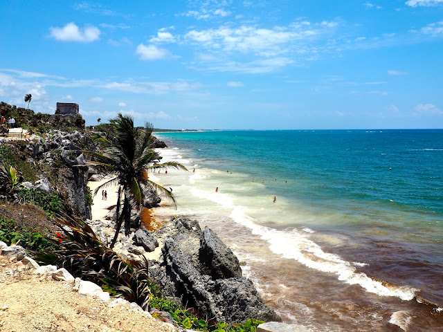 Palm trees & ruins on the cliff side, overlooking the beach and ocean at Tulum, Mexico