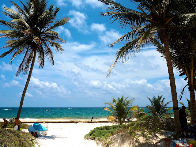 Palm trees, white sand and turquoise ocean at the beach at Tulum, Mexico