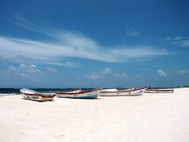 Small fishing boats on the white sand of Tulum beach, Mexico