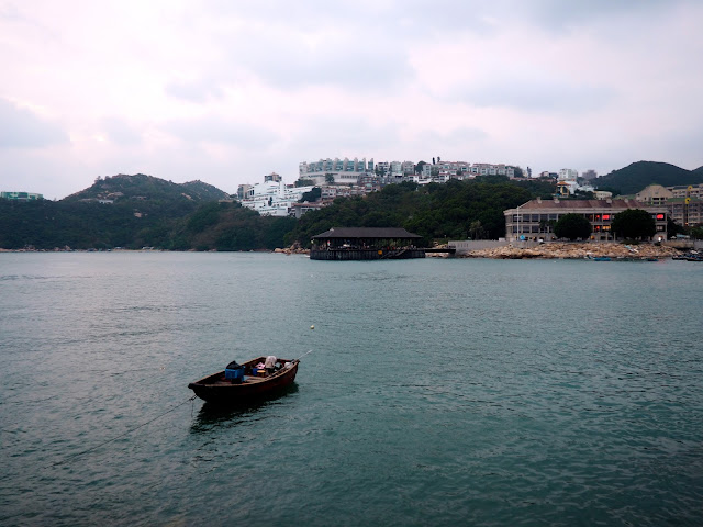 Stanley waterfront and harbour, with a small fishing boat and Blake Pier in the background, Hong Kong