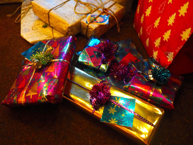 My Christmas presents to my family, wrapped in shiny purple, blue, gold and silver paper and ribbons