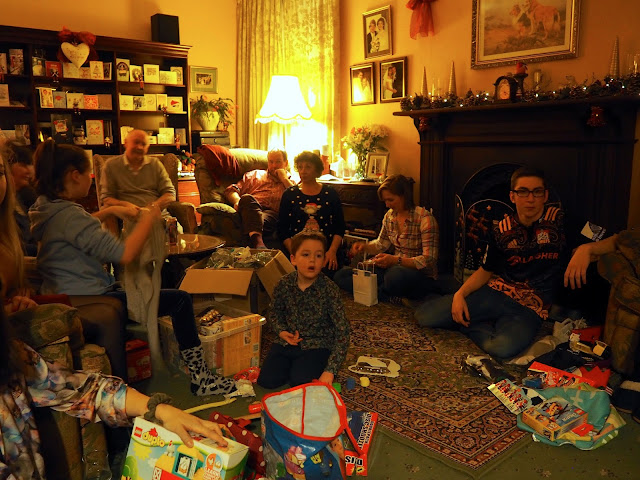 Family unwrapping presents together on Boxing Day