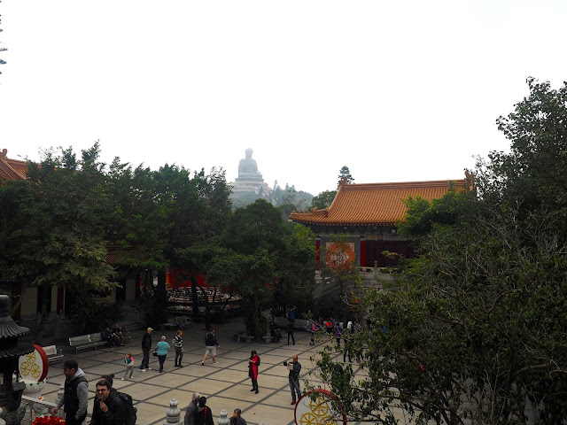 View of Po Lin Monastery courtyard, with Big Buddha statue on the hill in the background, Ngong Ping, Lantau Island, Hong Kong