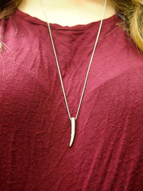 Wine Red | outfit jewellery details of silver fang pendant necklace against red top
