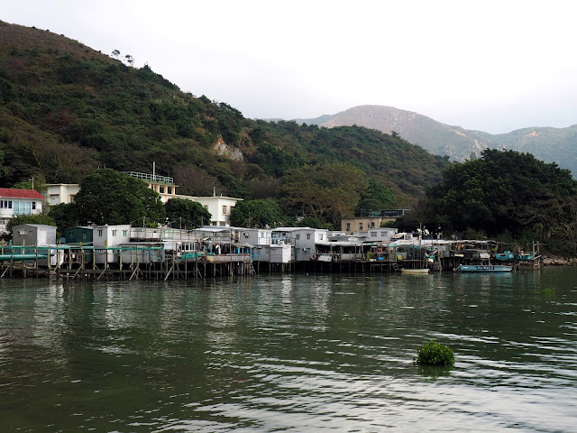 View of row of stilt houses in the distance, by the ocean at Tai O fishing village, Lantau Island, Hong Kong