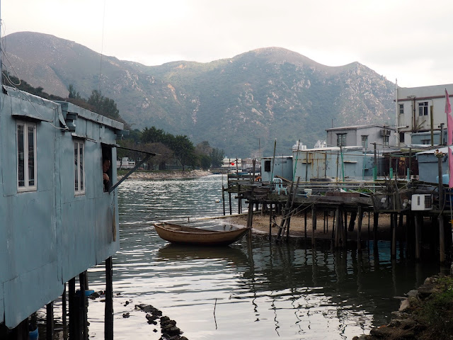 Stilt houses and a lone fishing boat at Tai O fishing village, Lantau Island, Hong Kong