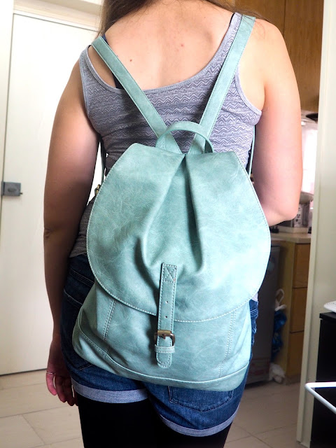 Hiking | outfit details from the back, of mint green leather effect backpack, with drawstring and flap close