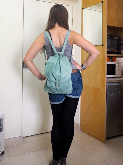 Hiking | outfit of light grey top, denim shorts, black leggings and high-top Converse - seen from the back with mint green backpack