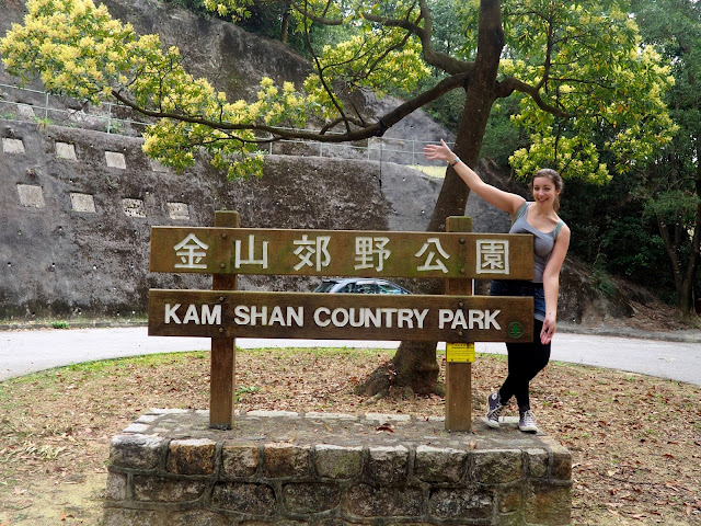 Girl posing with the Kam Shan Country Park sign, at the end of Monkey Mountain trail, near Tsuen Wan, New Territories, Hong Kong
