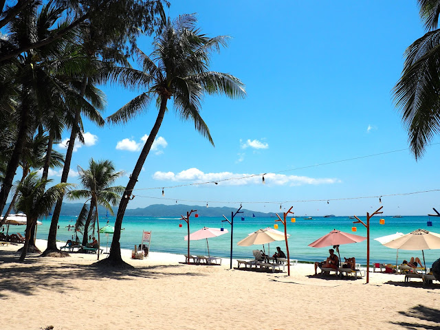 Palm trees, sand and ocean on White Beach, Boracay, Philippines