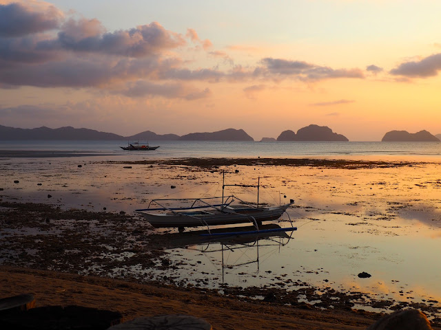 Boat in the shallows at sunset at Corong Corong Beach, near El Nido, Palawan, Philippines