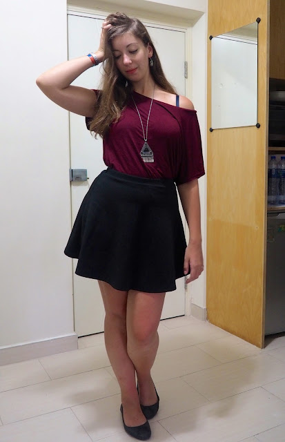 Inverted | outfit of loose off-the-shoulder burgundy red top, short black skater skirt, and flat black ballet pumps