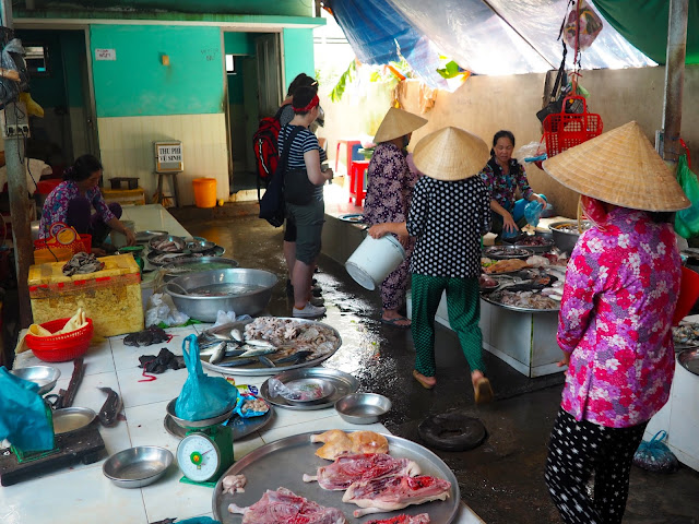 Seafood for sale at the local market, with women wearing traditional Vietnamese hats, in the Mekong Delta, Vietnam