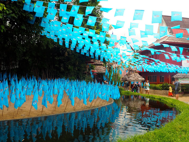Blue flags by a river feature and Buddha outside Wat Phan Tao, Chiang Mai, Thailand