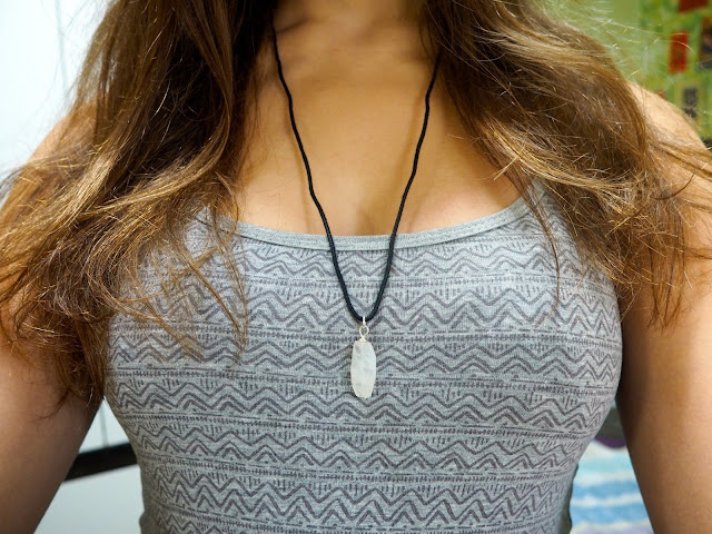 Slouching Around - outfit close up of grey geometric print pattern and white crystal on rope necklace