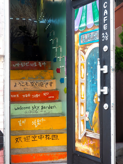 Mural painted on to a door and stairway - cafe entrance in Gamcheon Village, Busan, South Korea