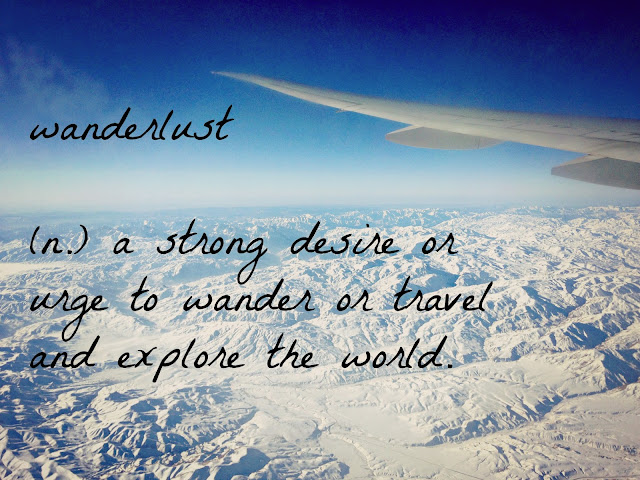 Wanderlust definition on background of snowy scene out an airplane window