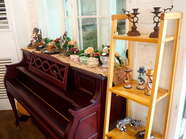 Cafe interior details - upright piano and shelves of ornaments in Marisstella cafe in Myeongnyun, Busan, South Korea
