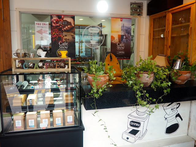 Cafe entrance interior details - coffee bean display and plant pots in Marisstella cafe in Myeongnyun, Busan, South Korea