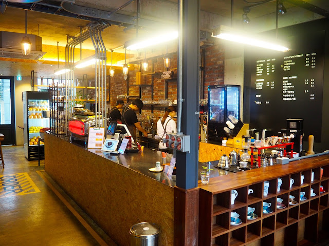Cafe interior - barista brewing station, menu and shelves of cups inside Red Velvet Cafe in Myeongnyun, Busan, South Korea