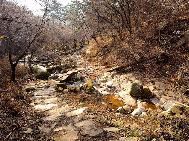 Stream crossing in the forest in autumn on a hiking trail on Geumjeongsan Mountain, Busan, South Korea