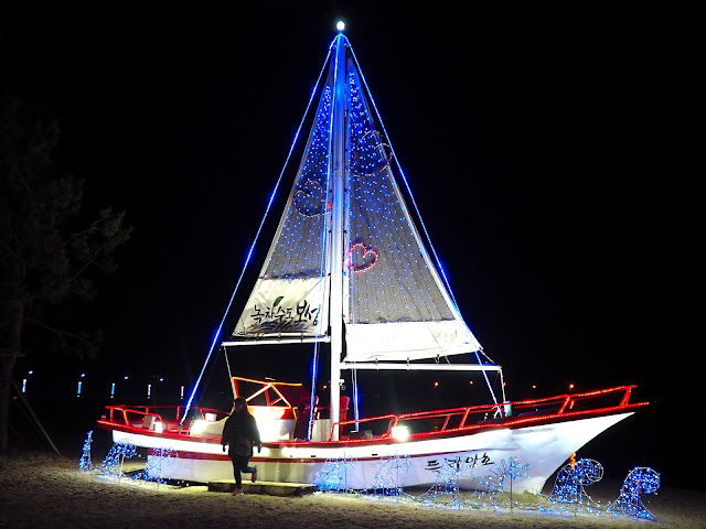 Sailing boat adorned with lights on the sand at the Light Festival at the Yulpo Beach area of Boseong Green Tea Plantation, South Korea