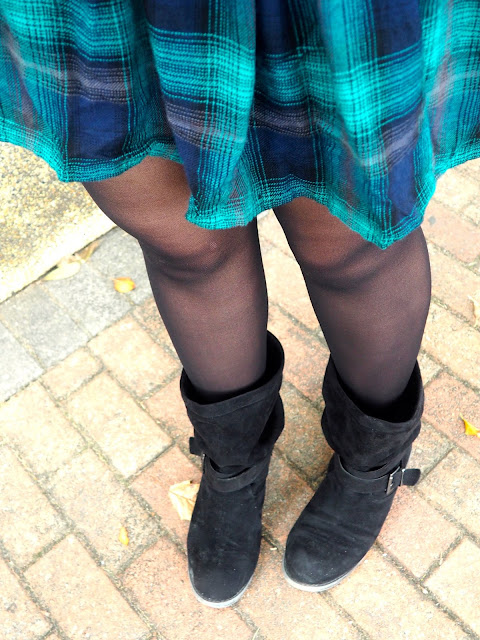 Hooded - outfit close up details of green tartan print dress hem, dark tights, and chunky, slouch, black suede boots