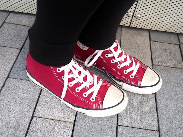 On The Move | outfit details of red high top Converse sneakers