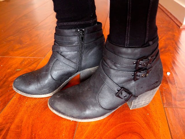 Oversized - outfit shoe details of heeled black leather ankle boots with buckles and straps