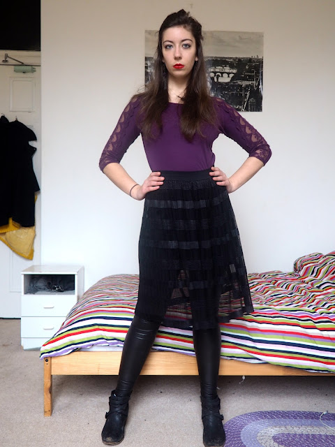 Ursula Disneybound outfit of purple lace sleeve top, black sheer skirt over leather effect leggings, and black ankle boots