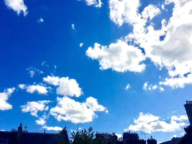 View of blue spring time sky with white clouds out the window, over Edinburgh