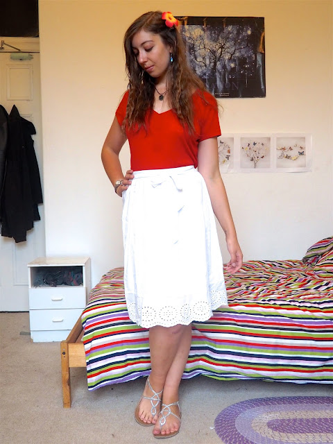 Moana inspired Disneybound outfit of bright red top, long white skirt, silver sandals, blue stone jewellery & island flower clip