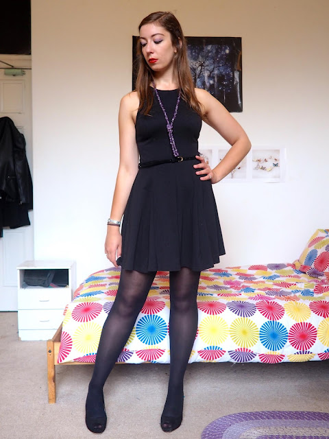 Maleficent inspired Disneybound outfit of little black dress with tights & high heels, and green & purple jewellery