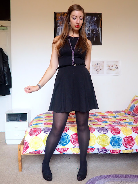 Maleficent inspired Disneybound outfit of little black dress with tights & high heels, and green & purple jewellery