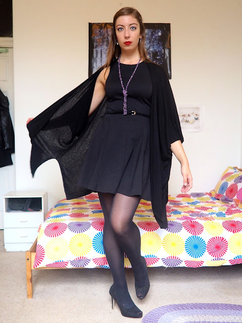 Maleficent inspired Disneybound outfit of little black dress with cape cardigan, tights & high heels, and green & purple jewellery