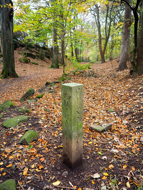 Hiking path stone marker in autumn woodlands on Corstorphine Hill, Edinburgh, Scotland