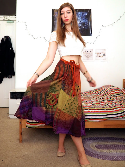 Esmeralda Disneybound outfit of white off the shoulder crop top, long rainbow pattern skirt, nude flats & bold jewellery