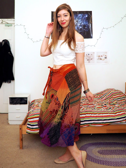 Esmeralda Disneybound outfit of white off the shoulder crop top, long rainbow pattern skirt, nude flats & bold jewellery